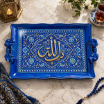 Cobalt blue tray with gold trim featuring a gilded Arabic calligraphy cartouche in a pointed arch amid flowering sprays