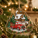 Clear Christmas acrylic hanging decor with a vintage red truck and snowy cabin design hanging on a lit Christmas tree.