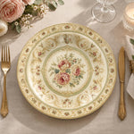 Ivory charger plate with gold trim featuring a pink rose medallion in a green ornamental border