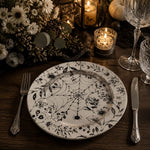 * Silver spider web charger plate on a white lace tablecloth with silver cutlery, crystal glassware, and white flowers.