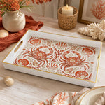 White tray with gold trim featuring decorative crab seashell and coral coastal pattern on warm ivory ground