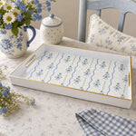White tray with gold trim featuring blue ribbon bows and forget-me-not flowers