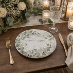 Rustic white wood-grain decorative charger plate with a watercolor eucalyptus and olive leaf wreath border for everyday table.