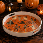 White tray with gold trim featuring Halloween skeleton ghost pumpkin orange party scene