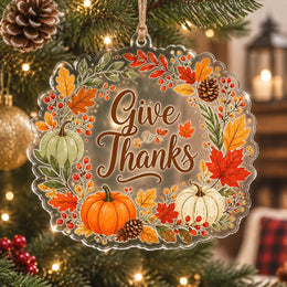Give Thanks acrylic hanging wall decor with autumn pumpkins and leaves hanging on a glowing holiday tree branch.