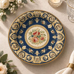 Navy blue charger plate with gold trim featuring a rose medallion and fleur-de-lis scroll border