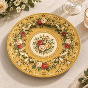 Golden yellow charger plate with gold trim featuring a floral wreath border around a rose medallion