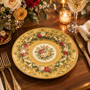 Golden yellow charger plate with gold trim featuring a floral wreath border around a rose medallion