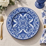 Navy blue charger plate with gold trim featuring white acanthus scroll medallion and leafy border