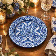 Navy blue charger plate with gold trim featuring white acanthus scroll medallion and leafy border