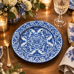 Navy blue charger plate with gold trim featuring white acanthus scroll medallion and leafy border
