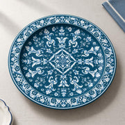 Teal blue charger plate featuring a white acanthus medallion and dense scrollwork border