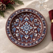 Burgundy charger plate featuring blue and white floral garland around a blossom medallion