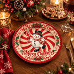 White charger plate with gold trim featuring a snowman on a peppermint swirl and holly border