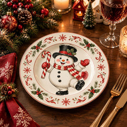 White charger plate with gold trim featuring a snowman framed by holly leaves and red berries
