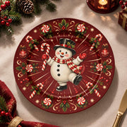 Red charger plate with gold trim featuring a snowman between radiating candy canes and snowflakes
