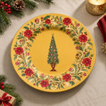 Golden charger plate with gold trim featuring a vintage tree in a wreath of red carnations