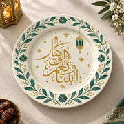 White charger plate with gold trim featuring Arabic calligraphy inside a green leaf border and lantern