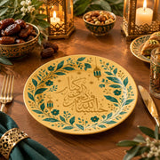 Amber charger plate with gold trim featuring Arabic calligraphy under a green leaf arc and lanterns