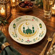 Ivory charger plate with gold trim featuring a crescent around a domed mosque and lanterns