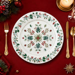 * Flat lay of a white Christmas charger plate featuring a festive green pine and red berry border design.