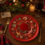 * Elegant red Christmas charger plate styled on a festive holiday dinner table setting with candles.
