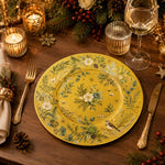 * Elegant Christmas gold charger plate set on a festive holiday dinner table decorated with candles and pine.