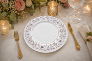 * Elegant white floral charger plates styled on a beautifully dressed wedding reception table with fine glassware.