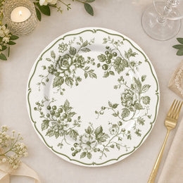 * White ceramic wedding charger plate with an elegant green and white floral pattern around the rim, top-down view.