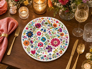 * Elegant white floral wedding charger plates set on a beautifully styled reception table with matching linens.