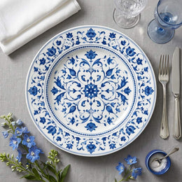 * Retro blue floral rose pattern on a white charger plate with elegant double-ring blue border, flat-lay view.