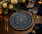 * Clear glass charger plates with gold rims styled on an elegant wedding reception table with white linens and florals.