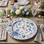 * White charger plates styled on an elegant wedding reception dinner table with white linens and gold cutlery.