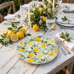 * Clear beaded charger plates set on a linen tablecloth with formal dinnerware for a wedding reception table setting.