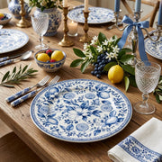 * A beautifully set dining table featuring white beaded charger plates under white dinnerware for an elegant wedding banquet.