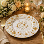 * Gold floral charger plate styled on a dinner table with gold flatware, white roses, and a lace napkin.