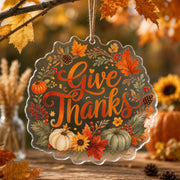 Give Thanks Acrylic Hanging Wall Decor – Pumpkin & Fall Leaves clear acrylic hanging wall decor with back-printed illustration, scalloped die-cut silhouette, hung with natural jute twine.