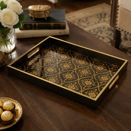 Islamic Geometric Serving Tray, Black Gold Moroccan Tile Pattern on a dark wood coffee table, featuring jewel-toned dahlias, marigolds, and bellflowers on a deep umber ground in a Jacobean-inspired vine, displayed on a tempered glass base with an electroplated warm-wood frame and matching handles.