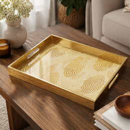 Fingerprint Art Glass Serving Tray – Gold Topographic on a coffee table, featuring UV-printed artwork on tempered glass with an electroplated frame and matching handles.