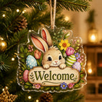 Easter bunny welcome acrylic hanging wall decor with pastel eggs, pink tulips, and daisies on clear acrylic with jute twine.