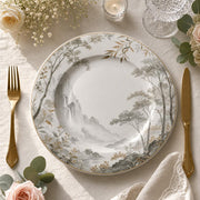 White ceramic decorative charger plate with a misty Chinese ink-wash mountain landscape, pine trees, and a gold rim for elegant dining.