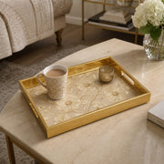 White Embroidered Floral Gold Decorative Tray with Couture Petals and Gold Frame | Minti Home styled on a console table with a ceramic mug and books beside a brass lamp.