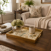 Persian Floral Decorative Tray with Gold Frame and Paisley Motifs | Minti Home styled on a console table with a ceramic mug and books beside a brass lamp.
