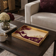Qatar Flag Wind Glass Serving Tray – Falcon Skyline styled on a console table with a ceramic mug and books beside a brass lamp.