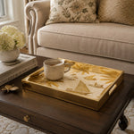 Gulf Coastline Glass Serving Tray – Palm Trees & Sailboats styled on a console table with a ceramic mug and books beside a brass lamp.