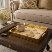 Gulf Coastline Glass Serving Tray – Palm Trees & Sailboats styled on a console table with a ceramic mug and books beside a brass lamp.
