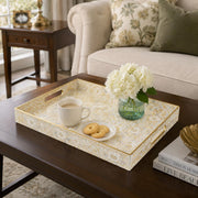 Cream Paisley Mosaic Plastic Serving Tray – Gold Scrollwork styled on a coffee table with books, a candle, and decorative accessories.