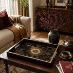 Persian Mandala Decorative Tray with Black and Gold Frame | Minti Home styled on a console table with a ceramic mug and books beside a brass lamp.