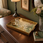 Indian Elephant Glass Serving Tray – Gold Floral Scrollwork styled on a console table with a ceramic mug and books beside a brass lamp.