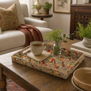 Gold Paisley Plastic Serving Tray – Vintage Floral Border styled on a coffee table with books, a candle, and decorative accessories.